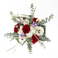 Crafted with a distinct eye for harmony, this Knightsbridge-inspired bouquet blends classic charm with understated confidence. Creamy white gerberas radiate from centered espresso-brown eyes, their dense petals offering a soft anchor among the lush, deep crimson roses, whose tightly furled petals speak of enduring affection and timeless style. Overhead, airy wisps of silvery-green eucalyptus extend outward, their motion suggesting the gentle breeze coursing through local squares near Harrods, while clusters of soft lavender lisianthus thread a contemporary accent through the traditional forms. Plush, cloud-like white filler blooms impart extra volume and a tactile softness, perfectly set off by the bouquet's foundation: broad, glossy green leaves sculpted artfully around the base, like attentive hands cradling the composition. The stems, clearly visible in pure water within the transparent vase, gleam with the promise of just-cut freshness-a testament to the florist's craft and pride in sourcing quality blooms for the heart of Knightsbridge. This arrangement radiates inviting fragrance-subtle, layered, faintly sweet with a touch of green-and is designed to brighten a new home, commemorate a special occasion, or offer gentle comfort to someone in SW1's close-knit community.